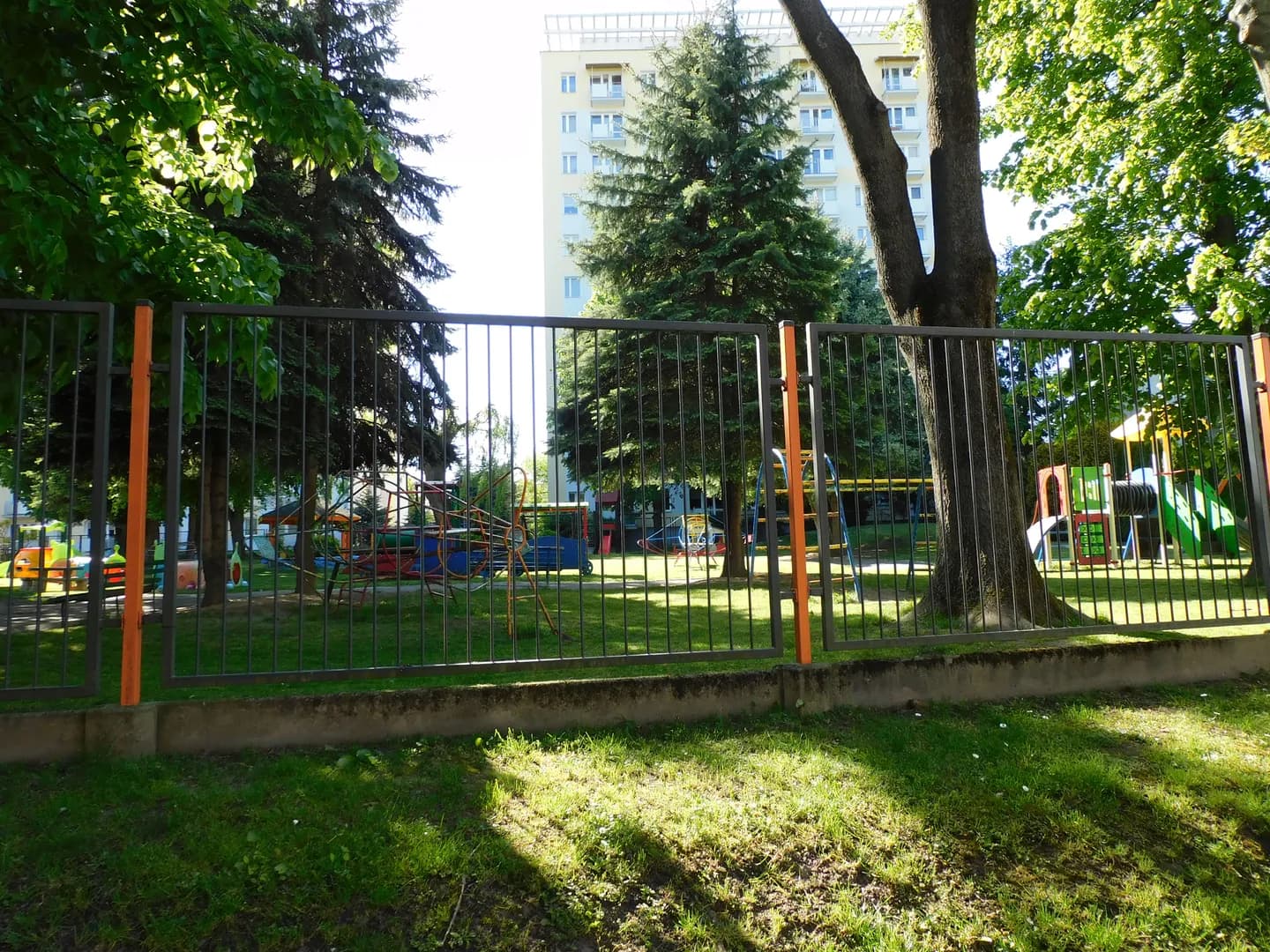 Plac zabaw Przedszkola Publicznego nr 16 w Rzeszowie widziany zza ogrodzenia