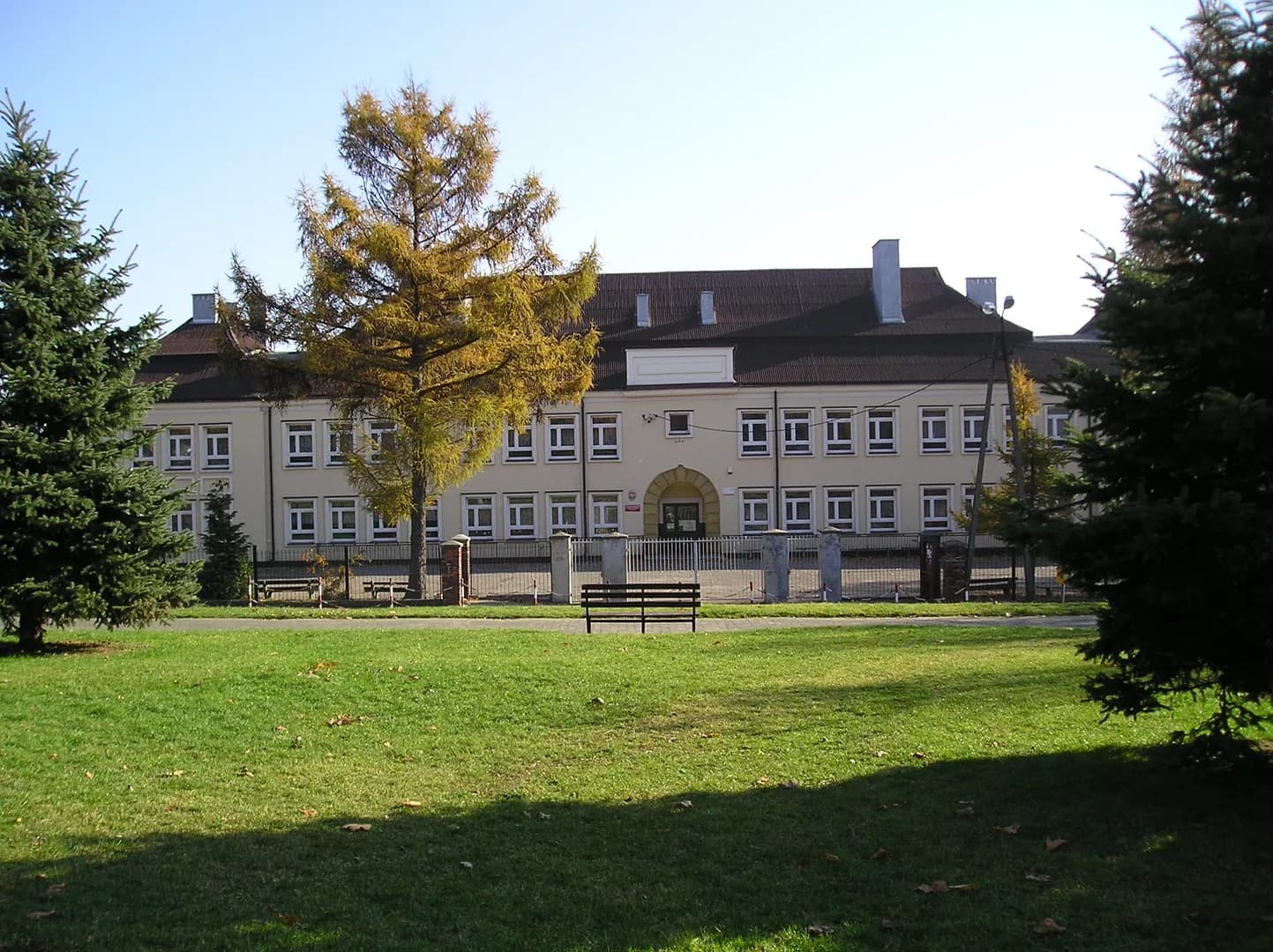 Widok na budynek Szkoły Podstawowej nr 1 w Sławkowie zza terenu zielonego