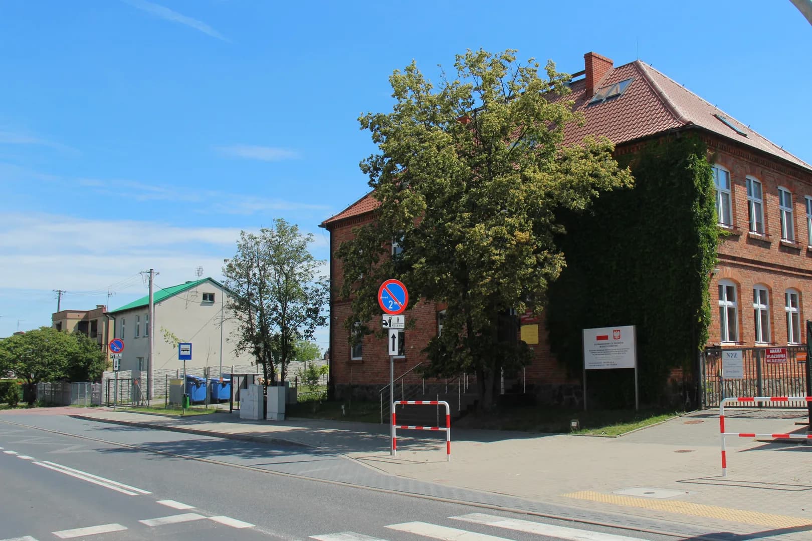 Ceglany budynek Szkoły Podstawowej w Konarzewie widziany od strony ulicy