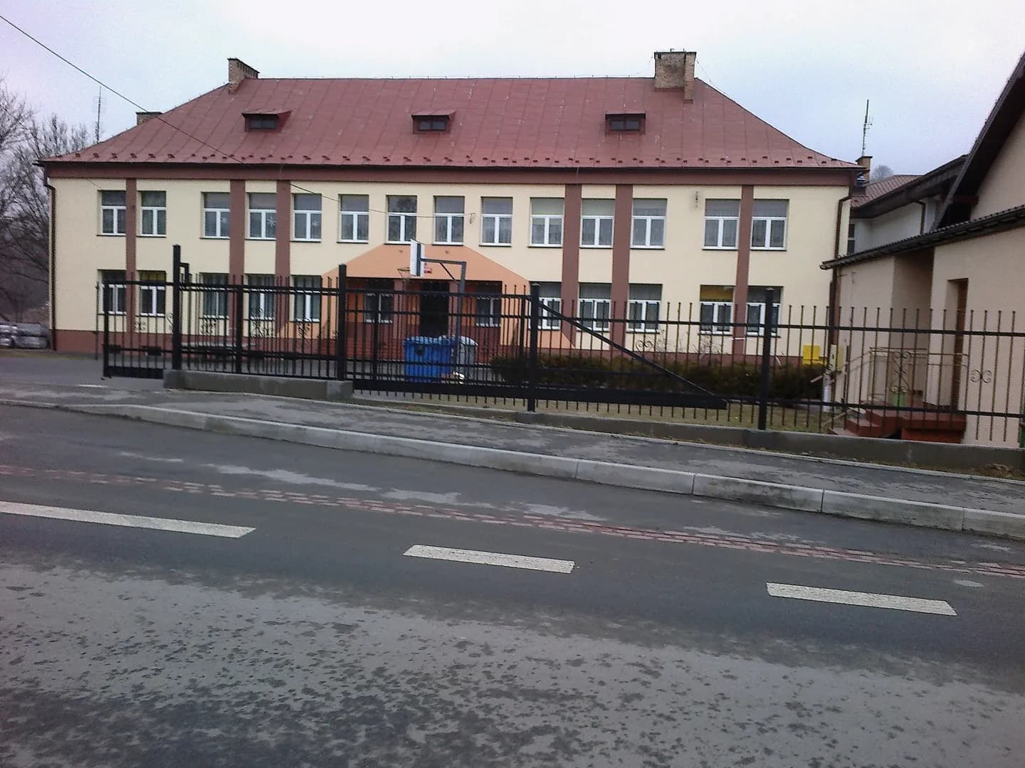 Budynek Szkoły Podstawowej w Czaszynie widoczny zza ogrodzenia