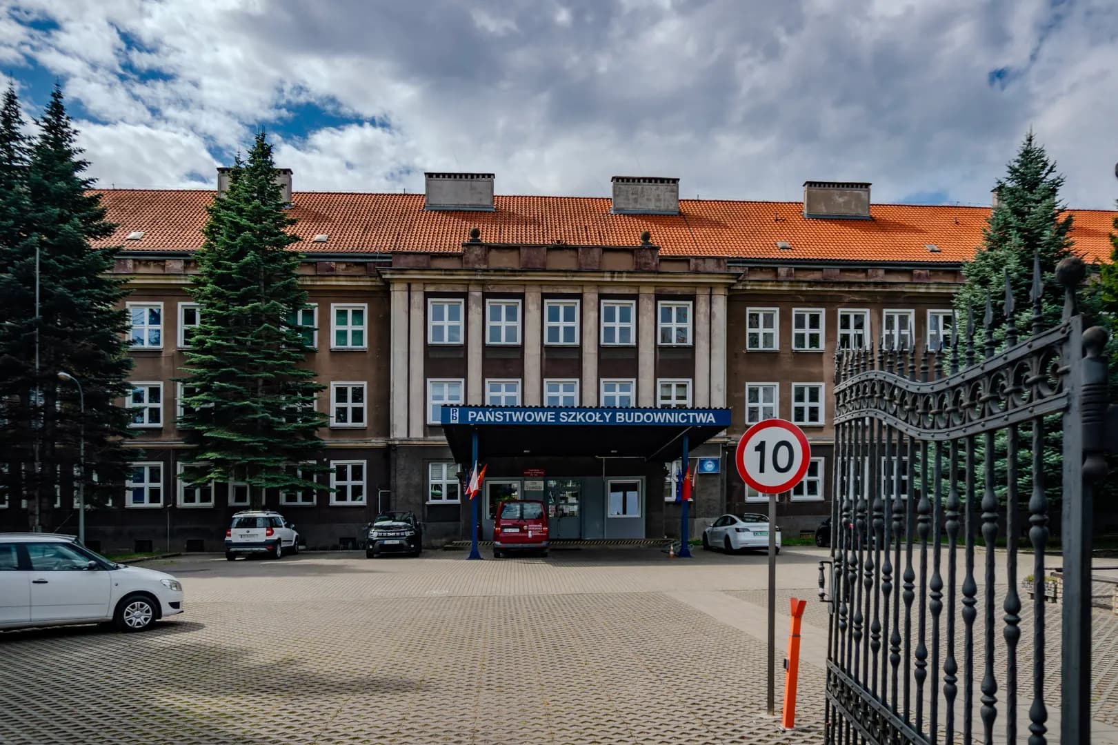 Fasada budynku Państwowych Szkół Budownictwa w Gdańsku z podjazdem i bramą