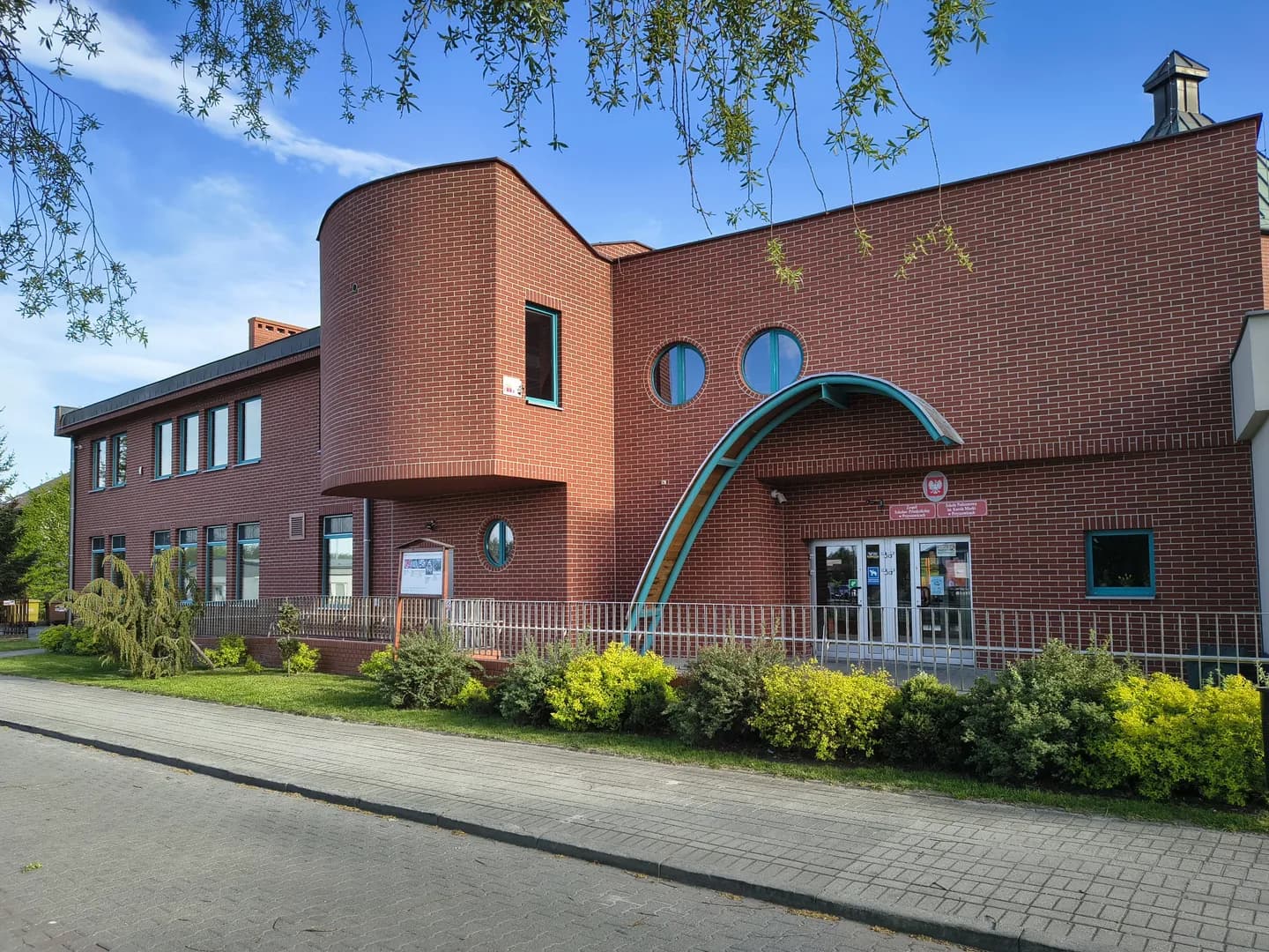 Ceglany budynek Zespołu Szkolno-Przedszkolnego w Przyszowicach z wejściem głównym