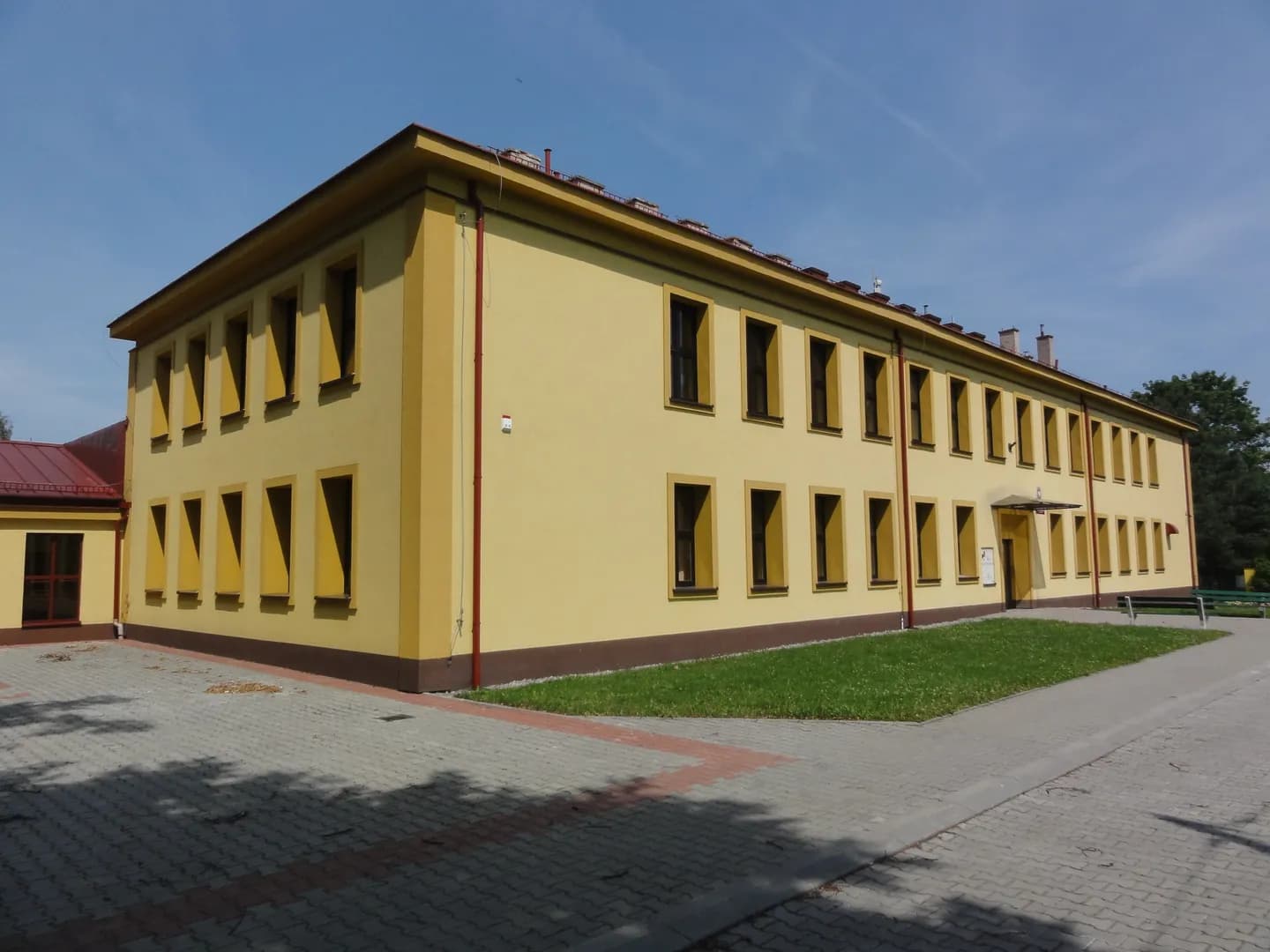 Żółty, piętrowy budynek Szkoły Podstawowej nr 2 w Ligocie od strony podwórza