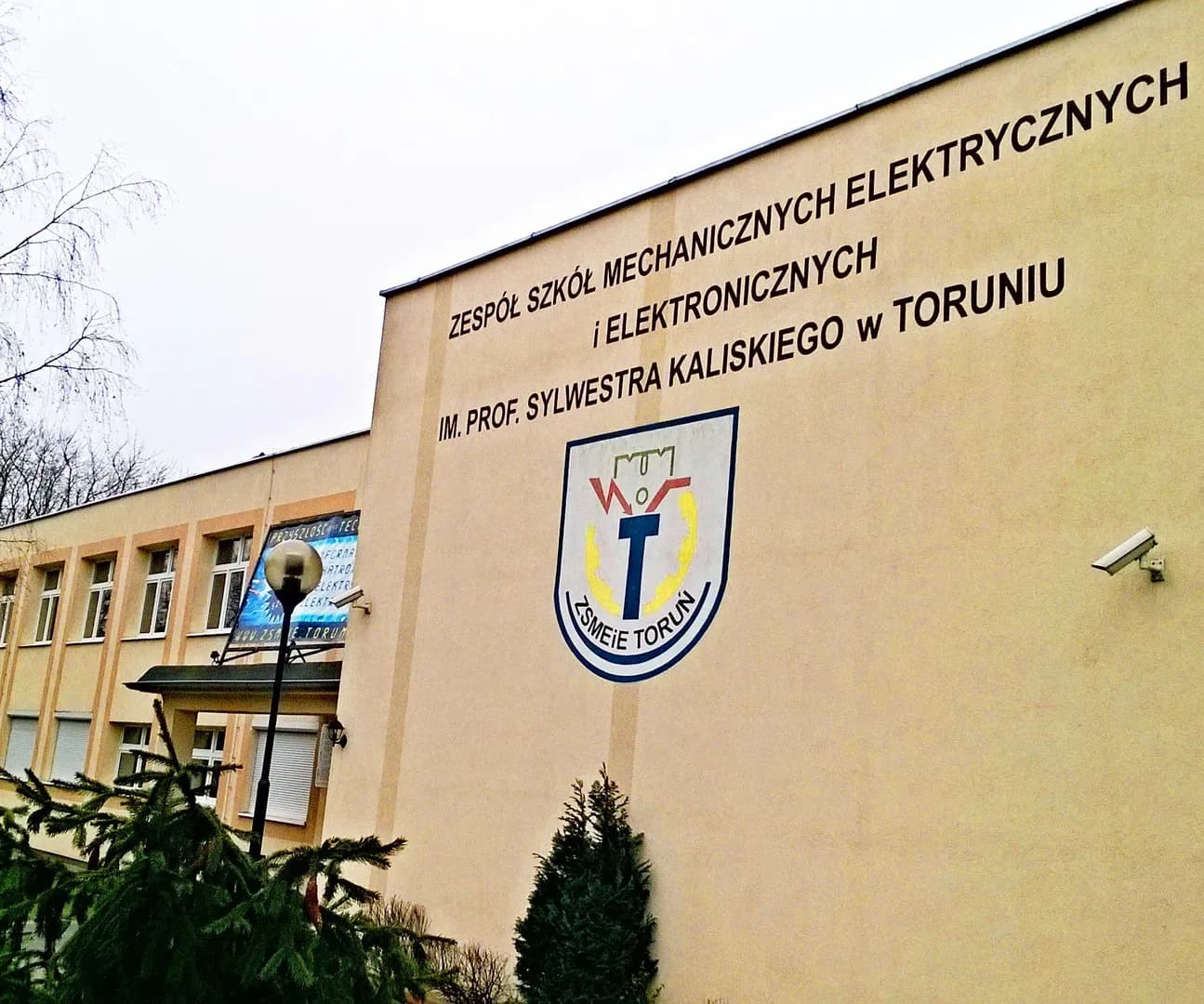 Elewacja budynku Zespołu Szkół Mechanicznych, Elektrycznych i Elektronicznych w Toruniu z nazwą szkoły i logo