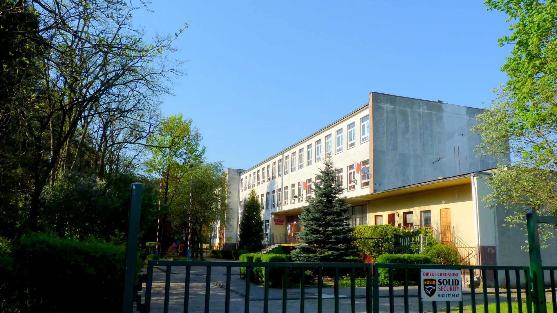 Budynek Zespołu Szkół nr 34 w Bydgoszczy widoczny zza ogrodzenia