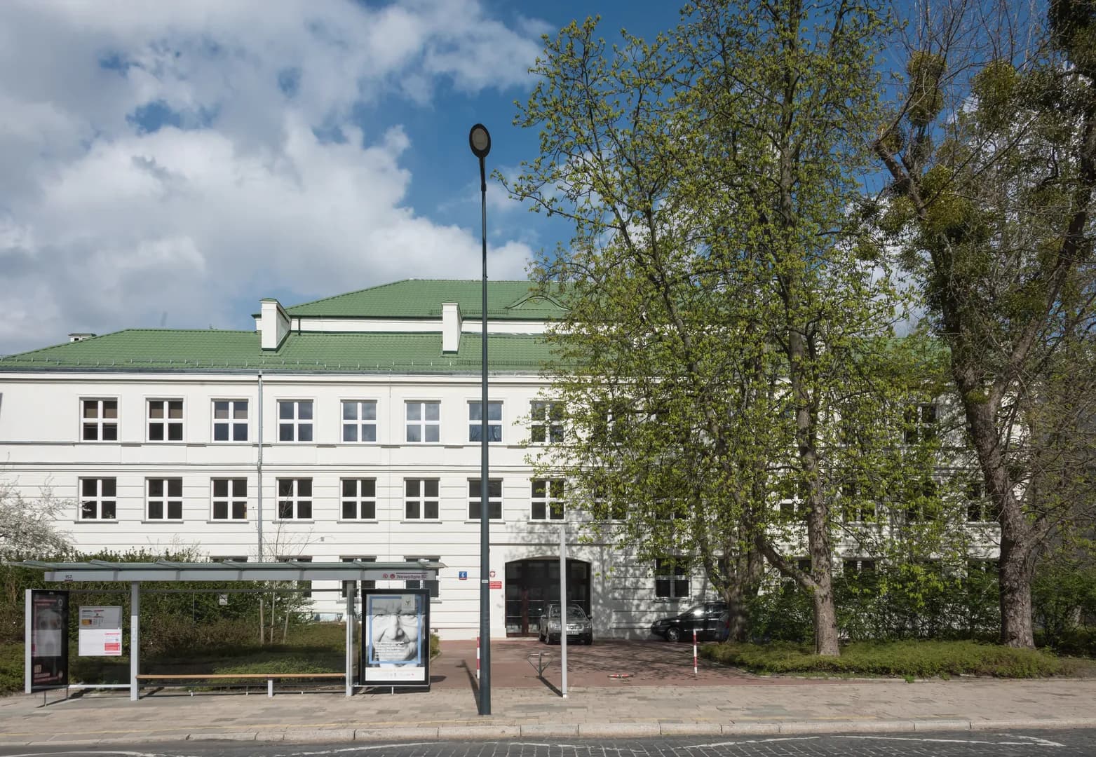 Fasada budynku Państwowego Liceum Sztuk Plastycznych im. Wojciecha Gersona w Warszawie widoczna zza przystanku