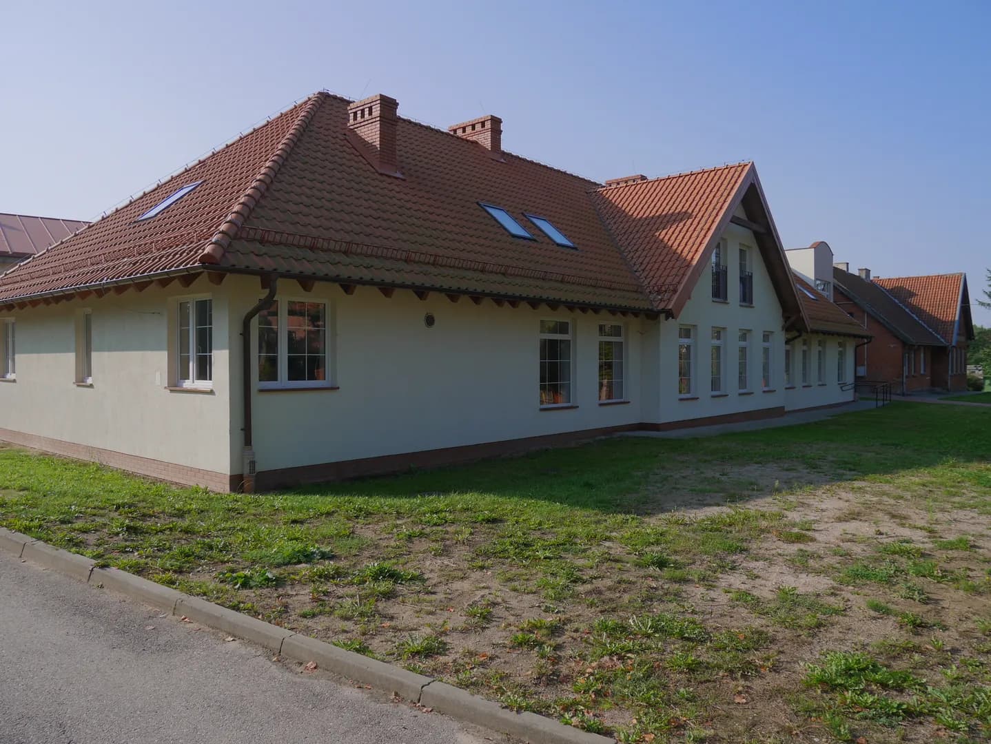 Parterowy budynek Szkoły Podstawowej w Borecznie z czerwonym dachem