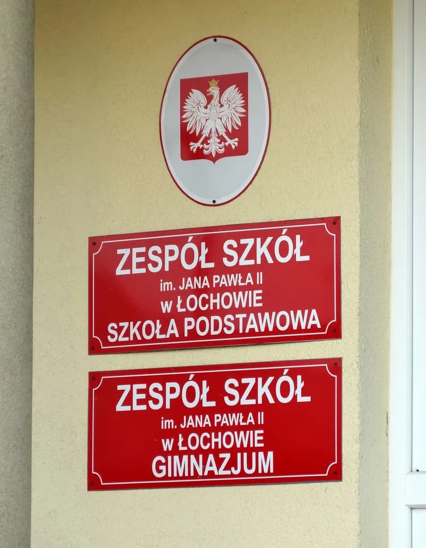 Tablice informacyjne na ścianie Zespołu Szkół im. Jana Pawła II w Łochowie
