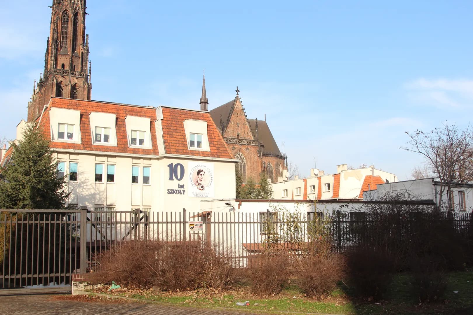 Budynek szkoły salezjańskiej we Wrocławiu z kościołem w tle
