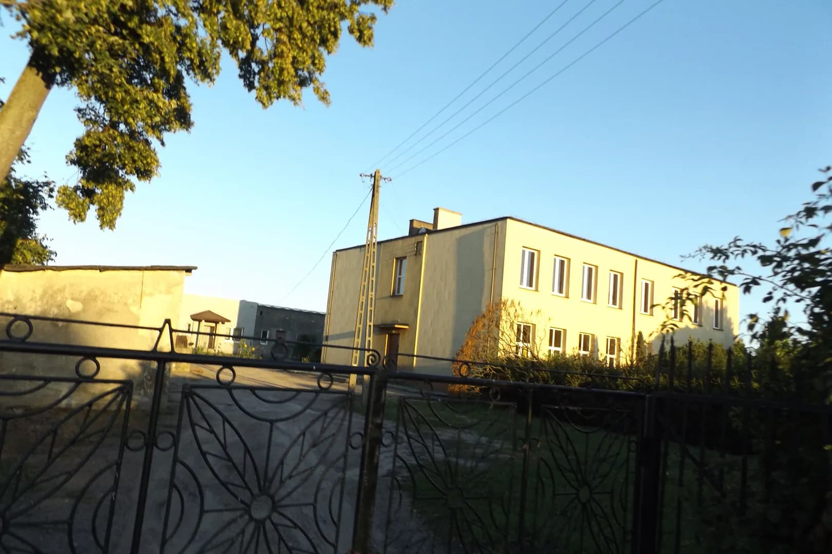 Budynek Szkoły Podstawowej w Grodźcu widziany zza ogrodzenia