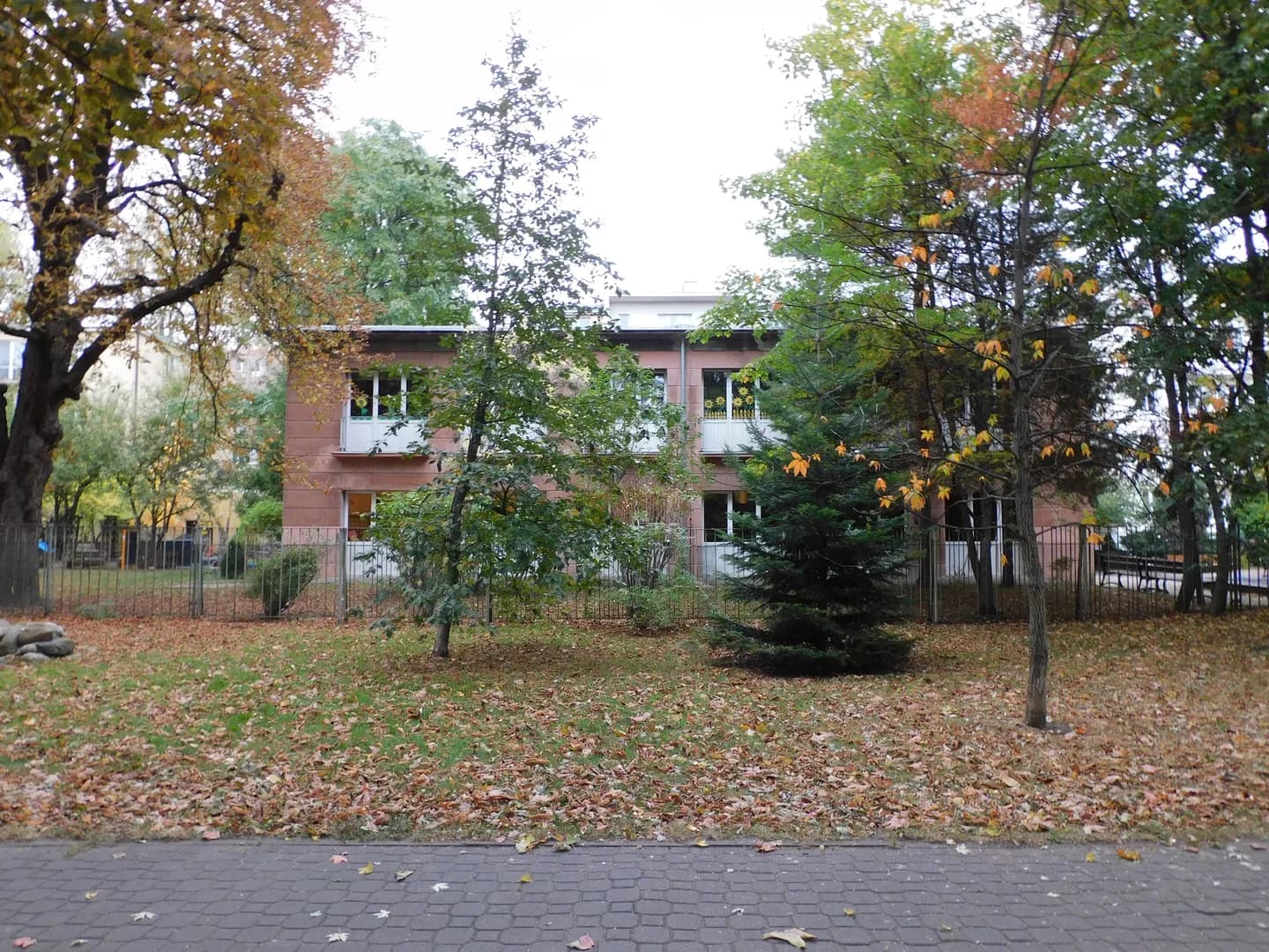 Budynek Przedszkola nr 131 w Warszawie widoczny zza drzew jesienią