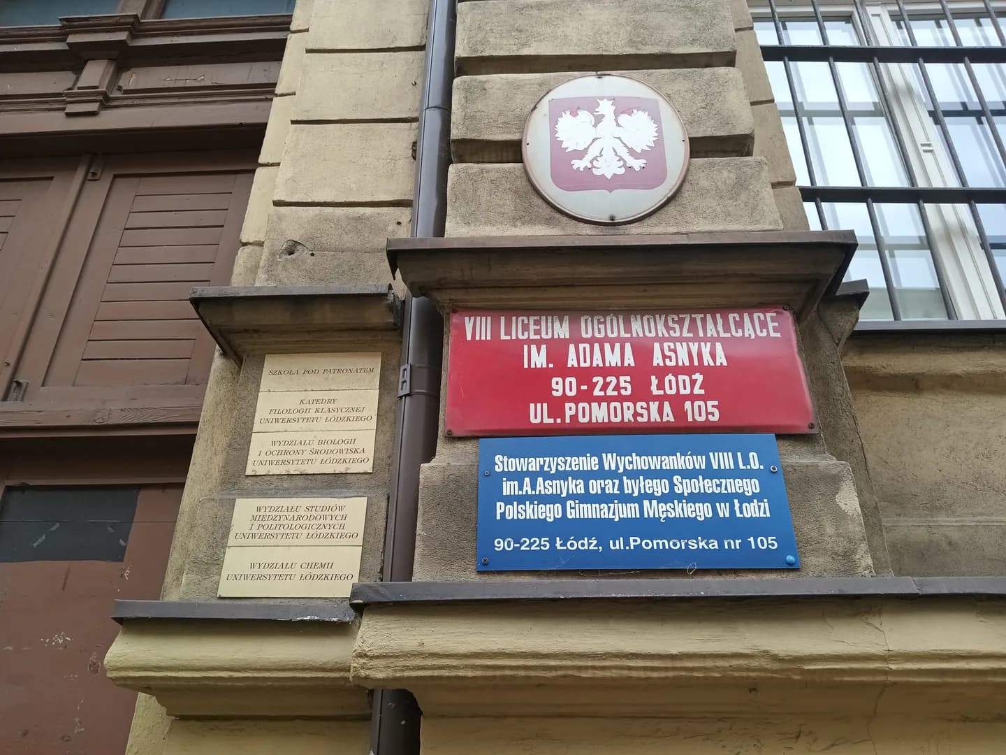 Tablice informacyjne na ścianie budynku VIII LO im. Adama Asnyka w Łodzi