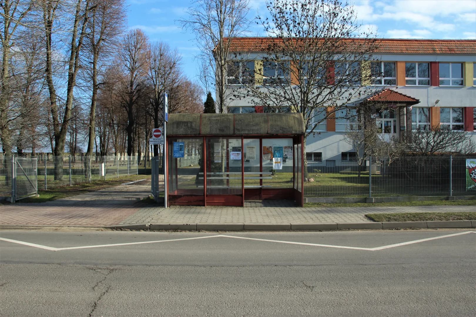 Widok na budynek Szkoły Podstawowej w Dobieżynie oraz przystanek autobusowy