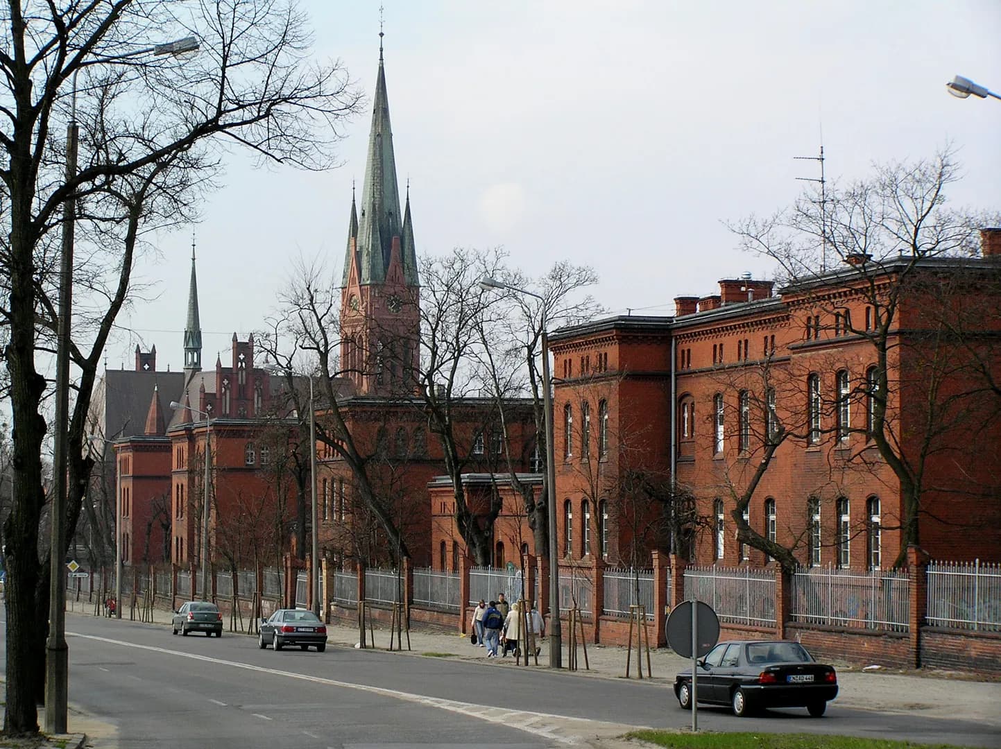 Widok z ulicy Dobrzyńskiej w Toruniu na ceglane budynki i wieżę kościoła św. Katarzyny