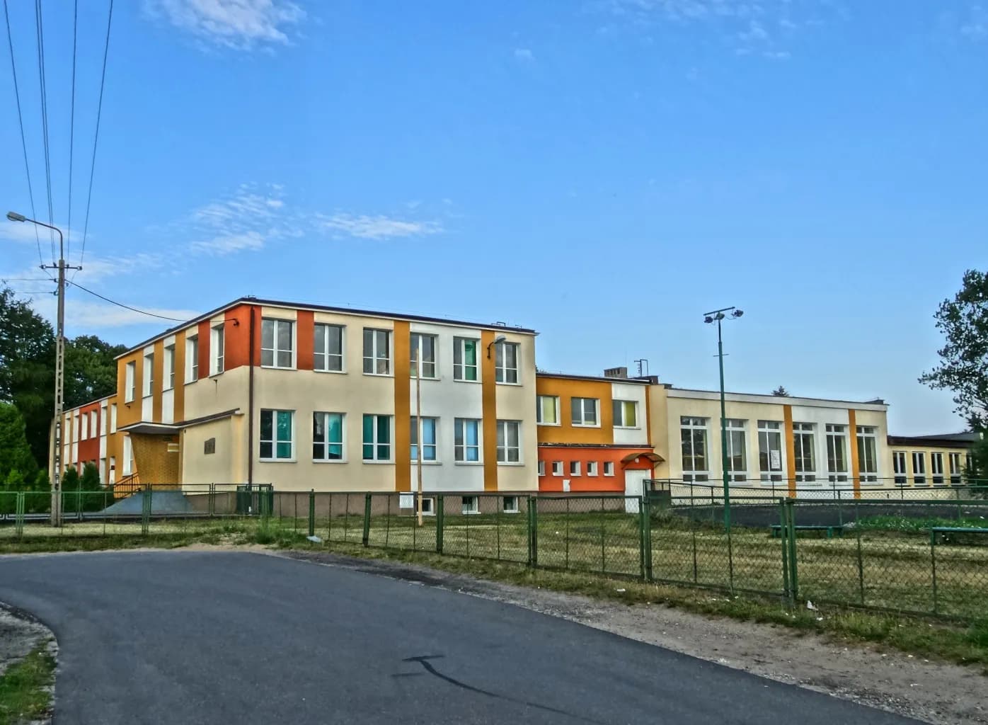 Elewacja Szkoły Podstawowej w Maksymilianowie z przylegającym boiskiem