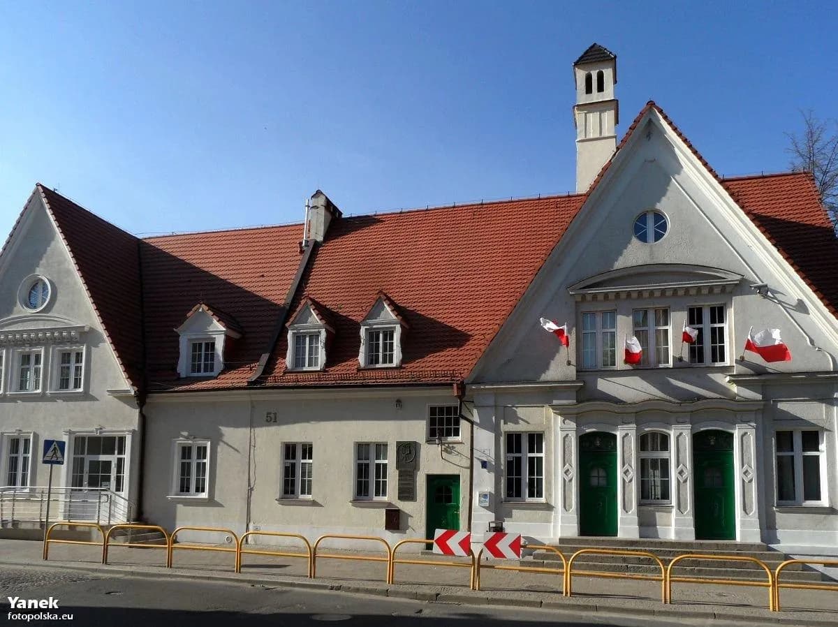 Elewacja budynku Gdańskiej Szkoły Podstawowej Lingwista z widocznymi polskimi flagami