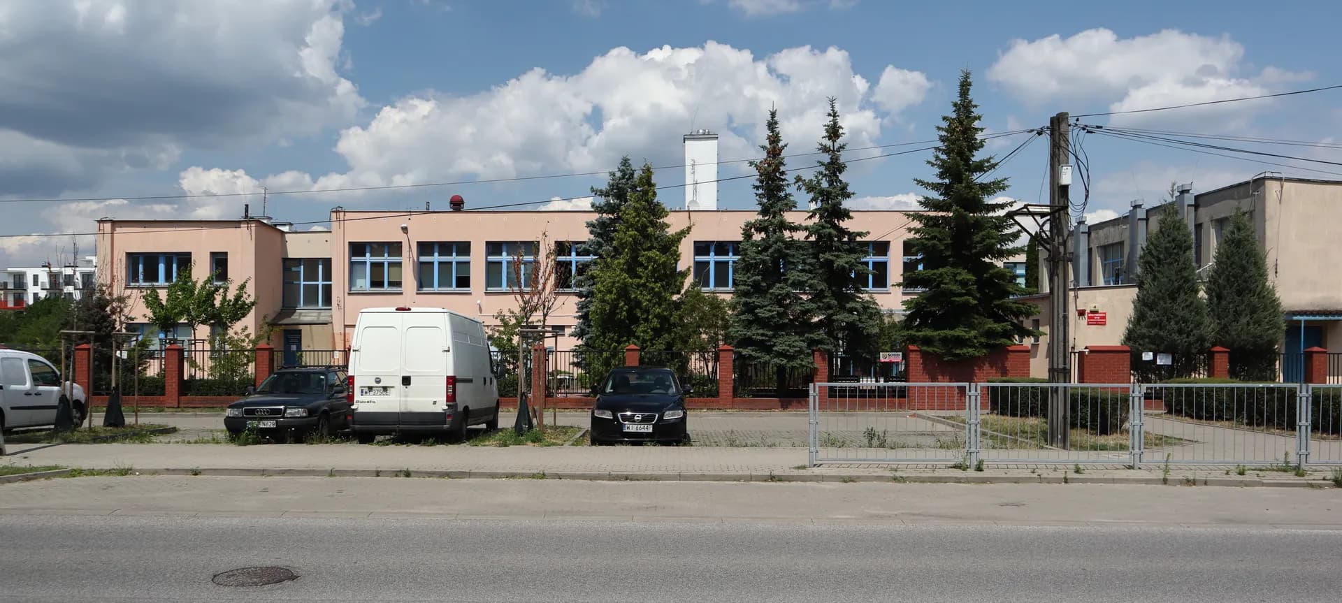 Budynek Szkoły Podstawowej nr 365 w Warszawie widoczny zza parkingu