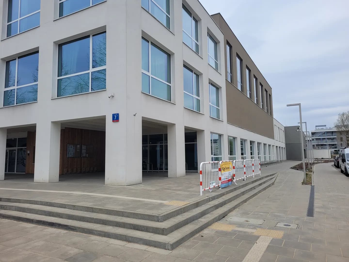 Nowoczesny budynek Szkoły Podstawowej nr 399 w Warszawie z widocznym wejściem i podjazdem.