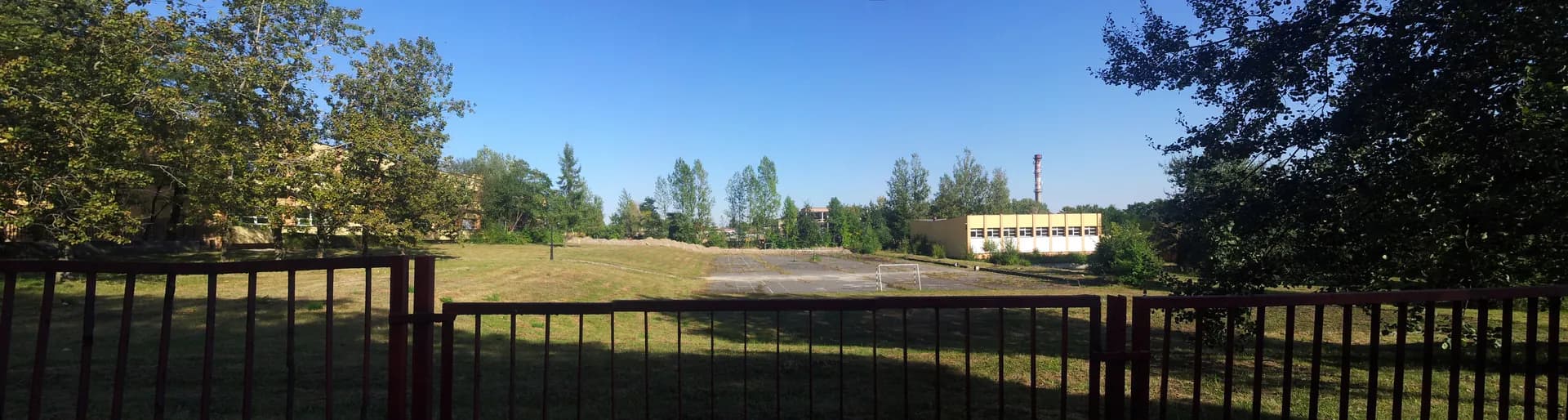 Boisko i tereny sportowe przy zespole szkół w Mikołowie widoczne zza ogrodzenia