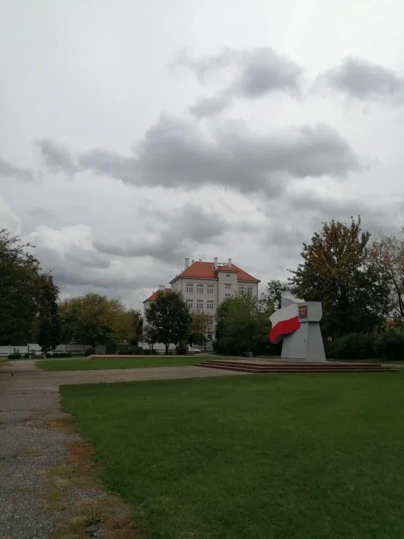 Widok na budynek III Liceum Ogólnokształcącego we Włocławku z placu z pomnikiem