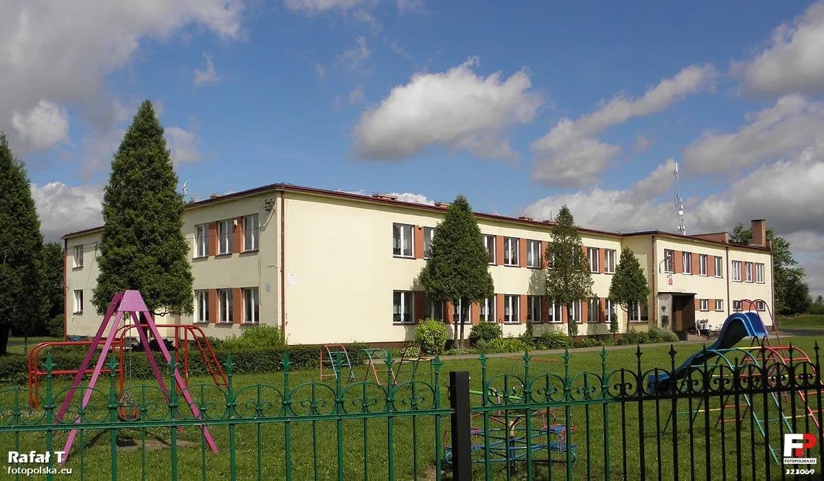 Budynek szkoły podstawowej w Młodocinie Mniejszym z widocznym placem zabaw