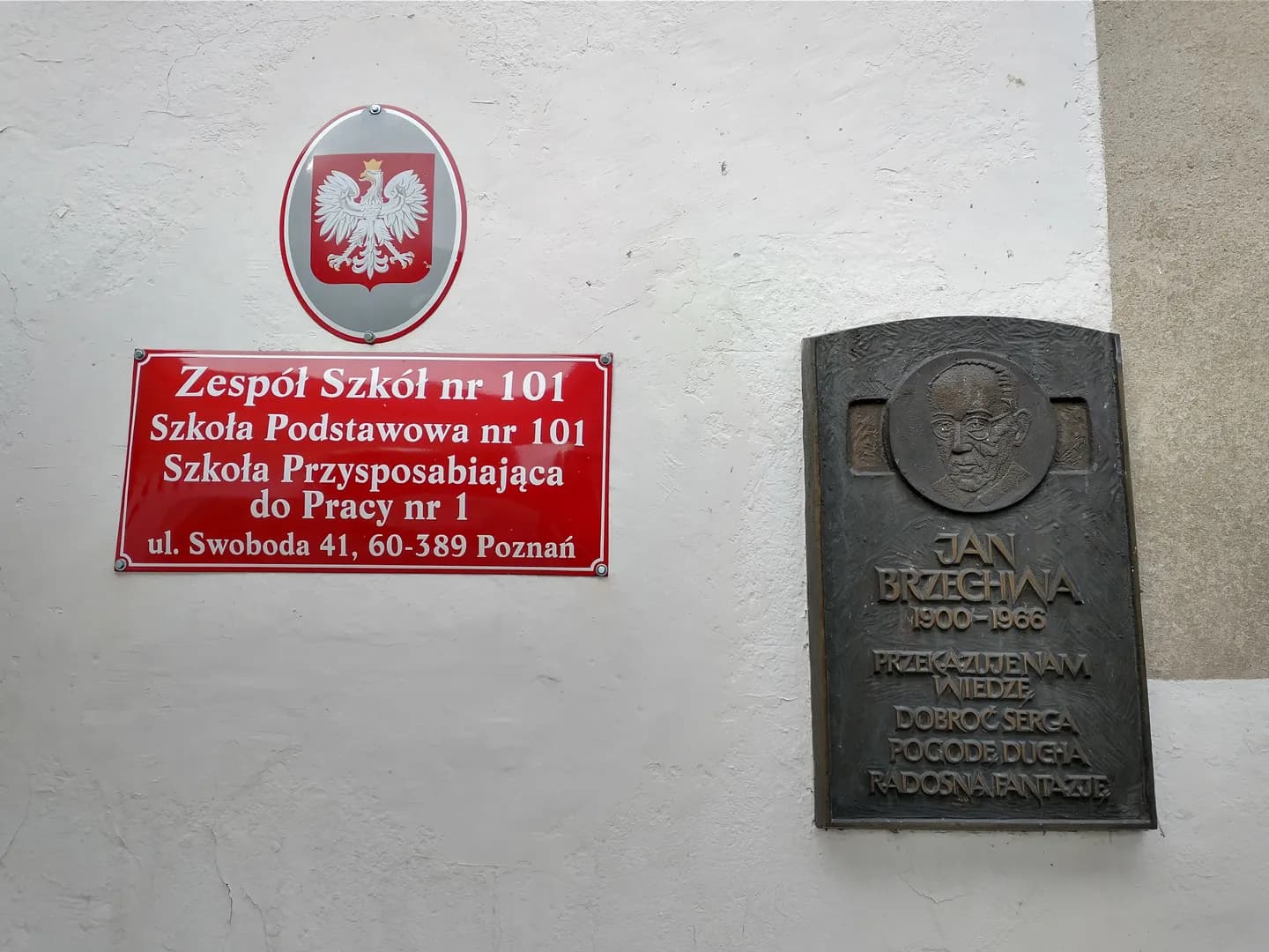 Tablice informacyjne i pamiątkowe na ścianie Zespołu Szkół nr 101 w Poznaniu