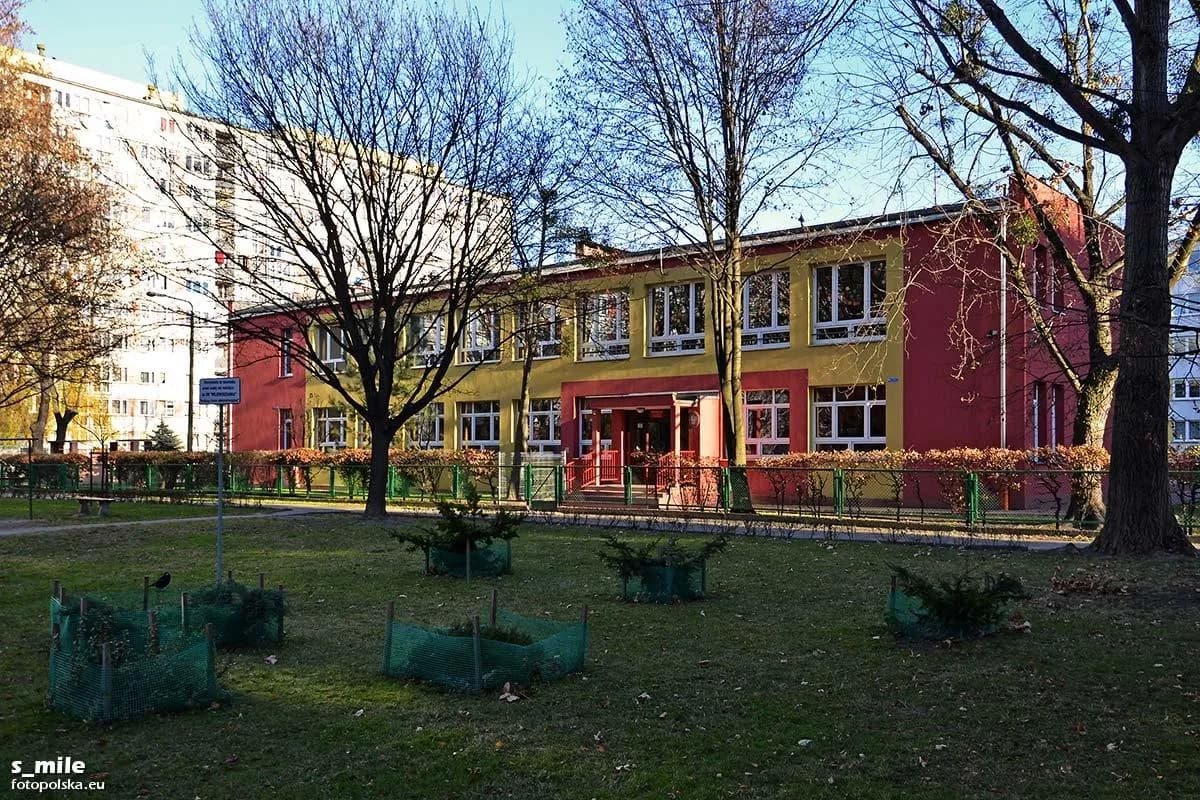 Budynek Przedszkola nr 108 we Wrocławiu widoczny zza drzew i trawnika