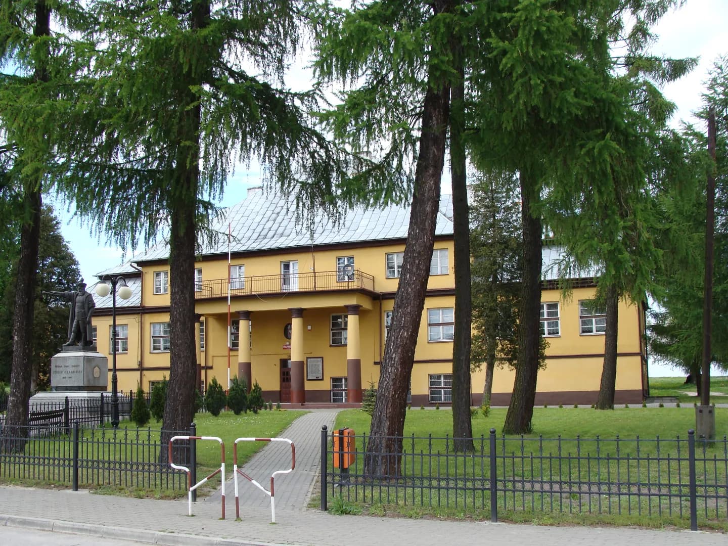 Budynek Szkoły Podstawowej im. Stefana Czarnieckiego w Czarncy z widocznym pomnikiem