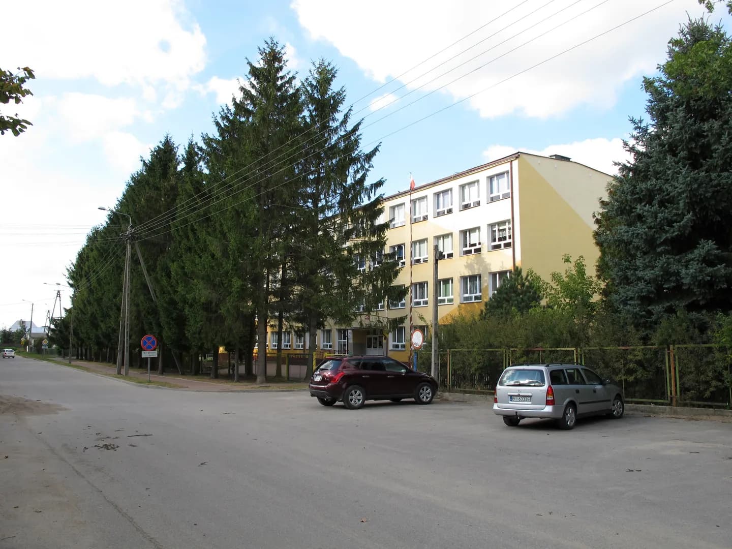 Budynek Zespołu Placówek Oświatowych w Suchowoli z widocznym parkingiem i drzewami