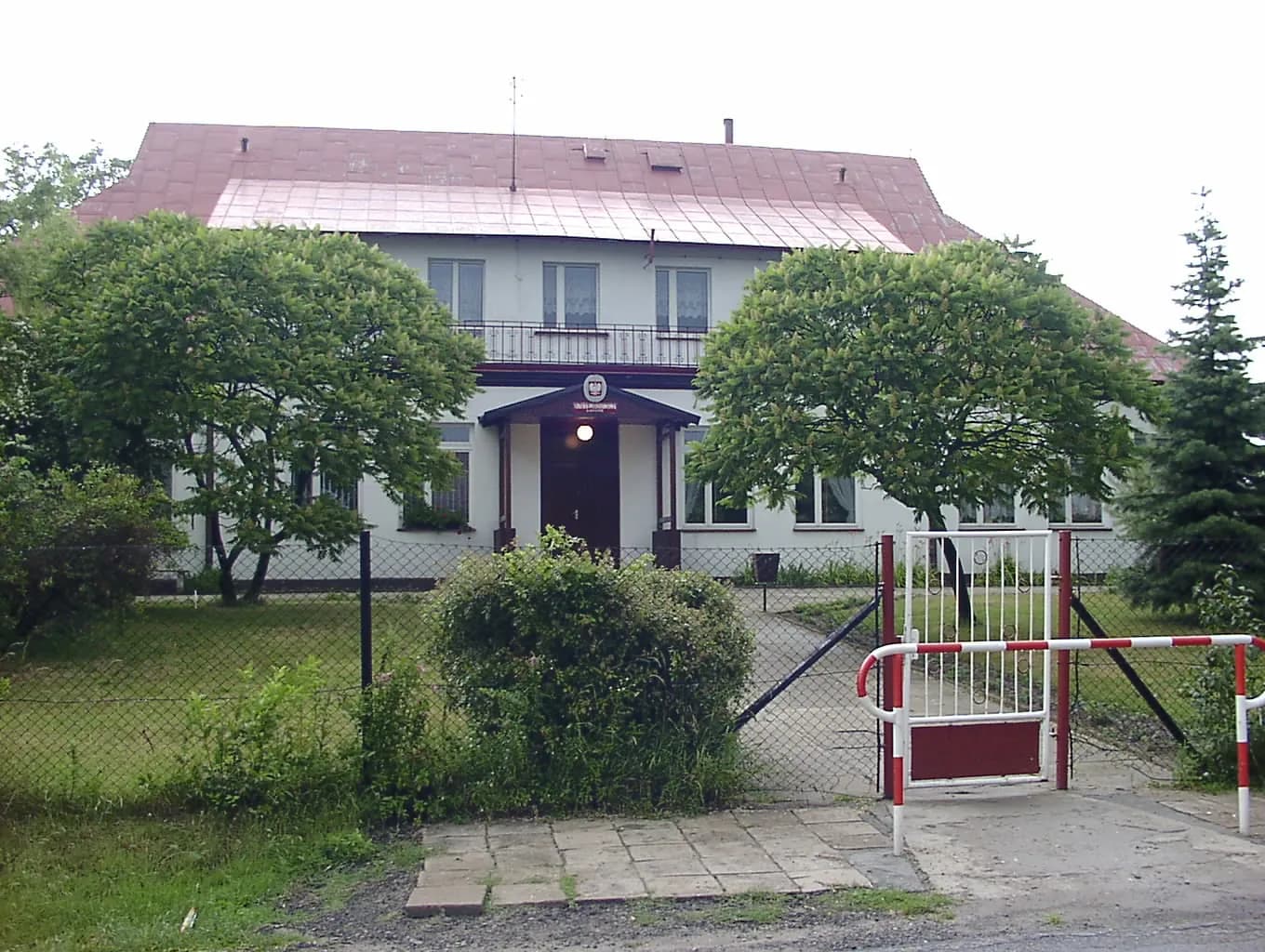 Budynek Szkoły Podstawowej w Gaszynie widziany zza ogrodzenia
