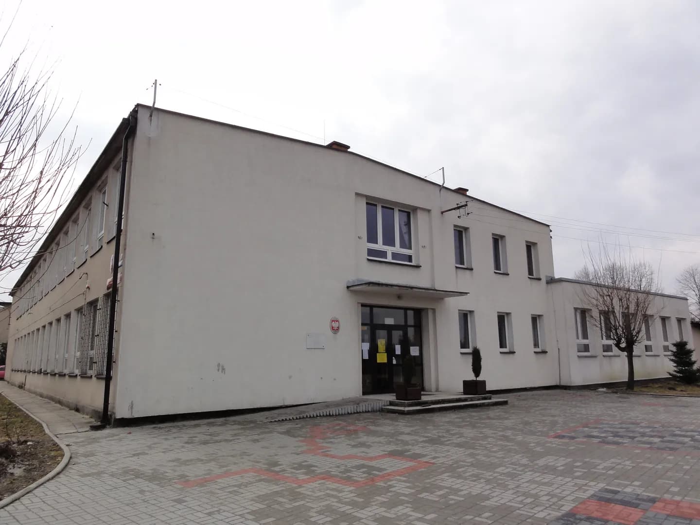 Budynek Zespołu Szkolno-Przedszkolnego w Zaborzu z wejściem głównym i placem