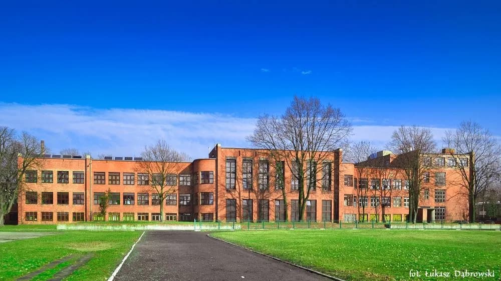 Ceglany budynek Zespołu Szkół Technicznych w Grudziądzu widziany od strony boiska