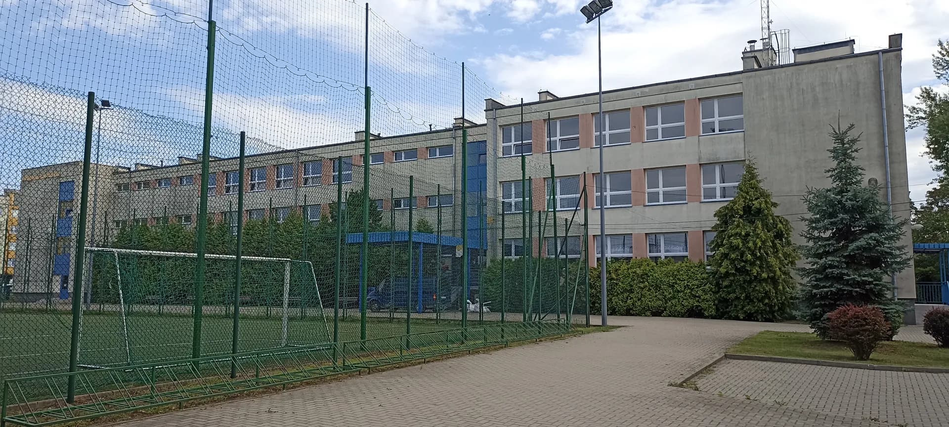 Budynek Szkoły Podstawowej nr 2 w Górze Kalwarii z boiskiem sportowym na pierwszym planie