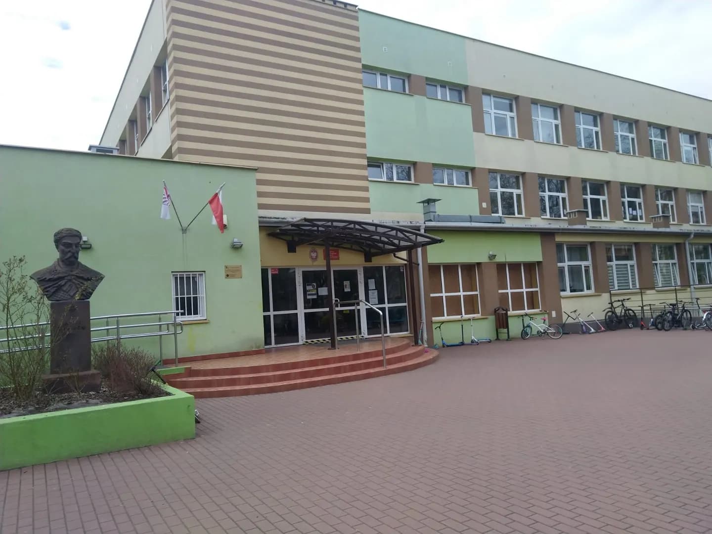 Wejście do budynku Szkoły Podstawowej nr 307 w Warszawie z popiersiem patrona