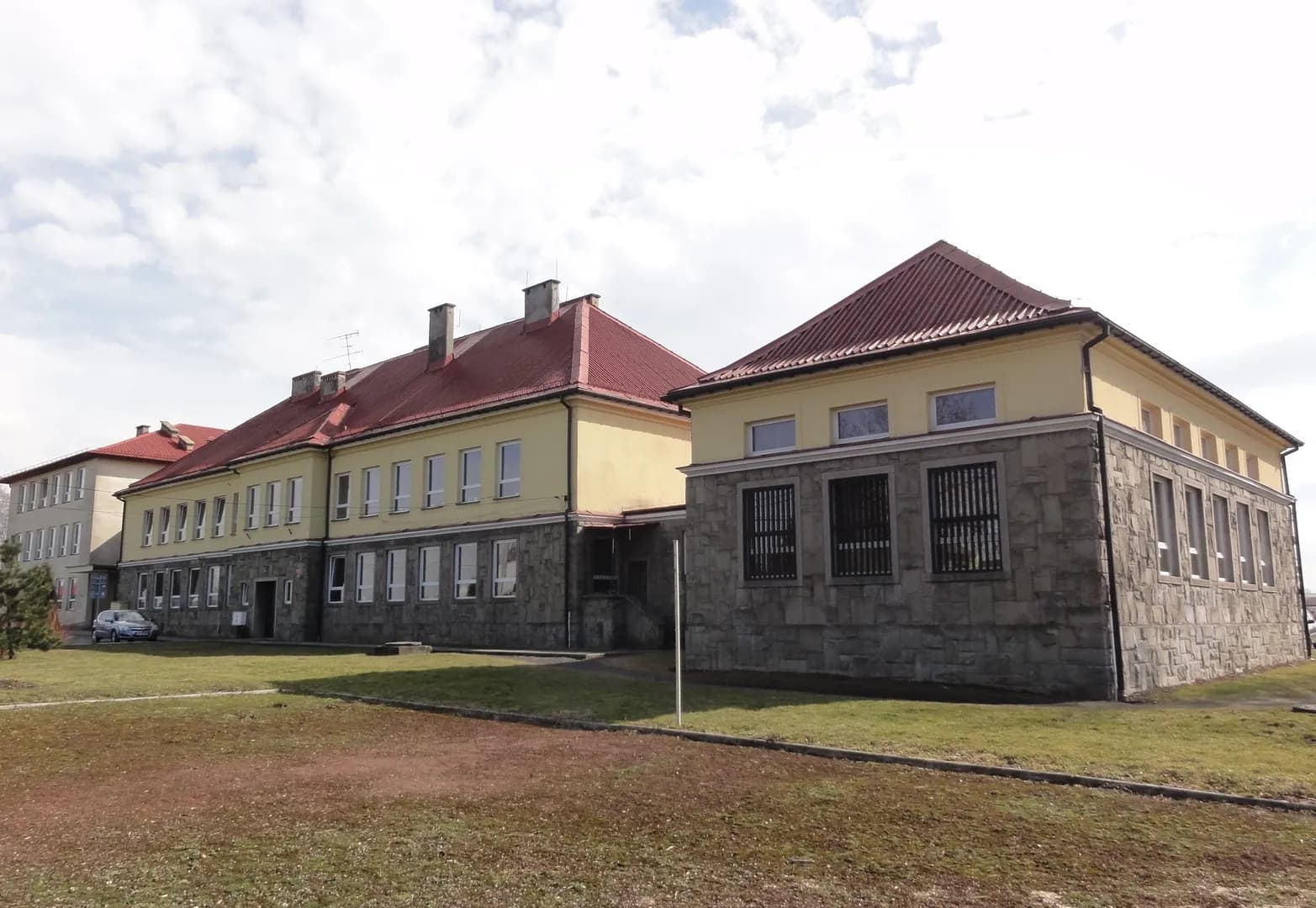 Budynek Szkoły Podstawowej w Pogwizdowie z widokiem na elewację i otoczenie