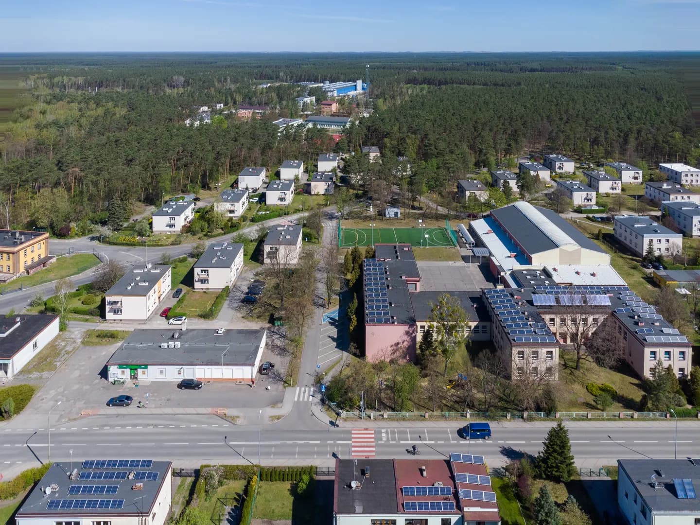 Widok z lotu ptaka na kompleks budynków Szkoły Podstawowej nr 1 w Krupskim Młynie i okoliczne osiedle.