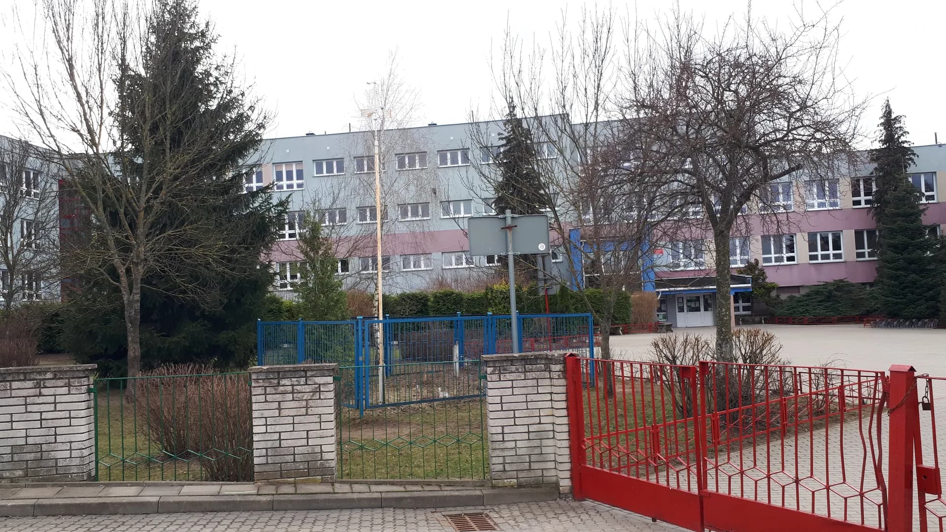 Widok na budynek Szkoły Podstawowej nr 45 w Białymstoku zza ogrodzenia