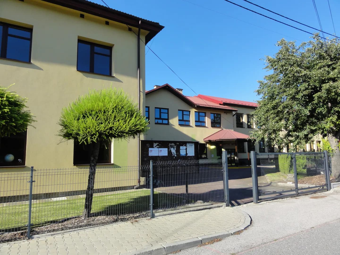 Budynek Szkoły Podstawowej w Roczynach za ogrodzeniem