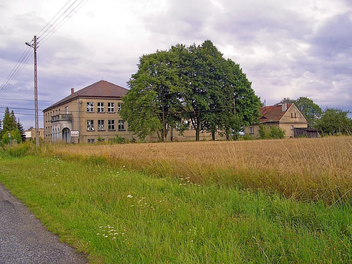 Widok na budynek szkoły w Bzinicy Starej zza pola
