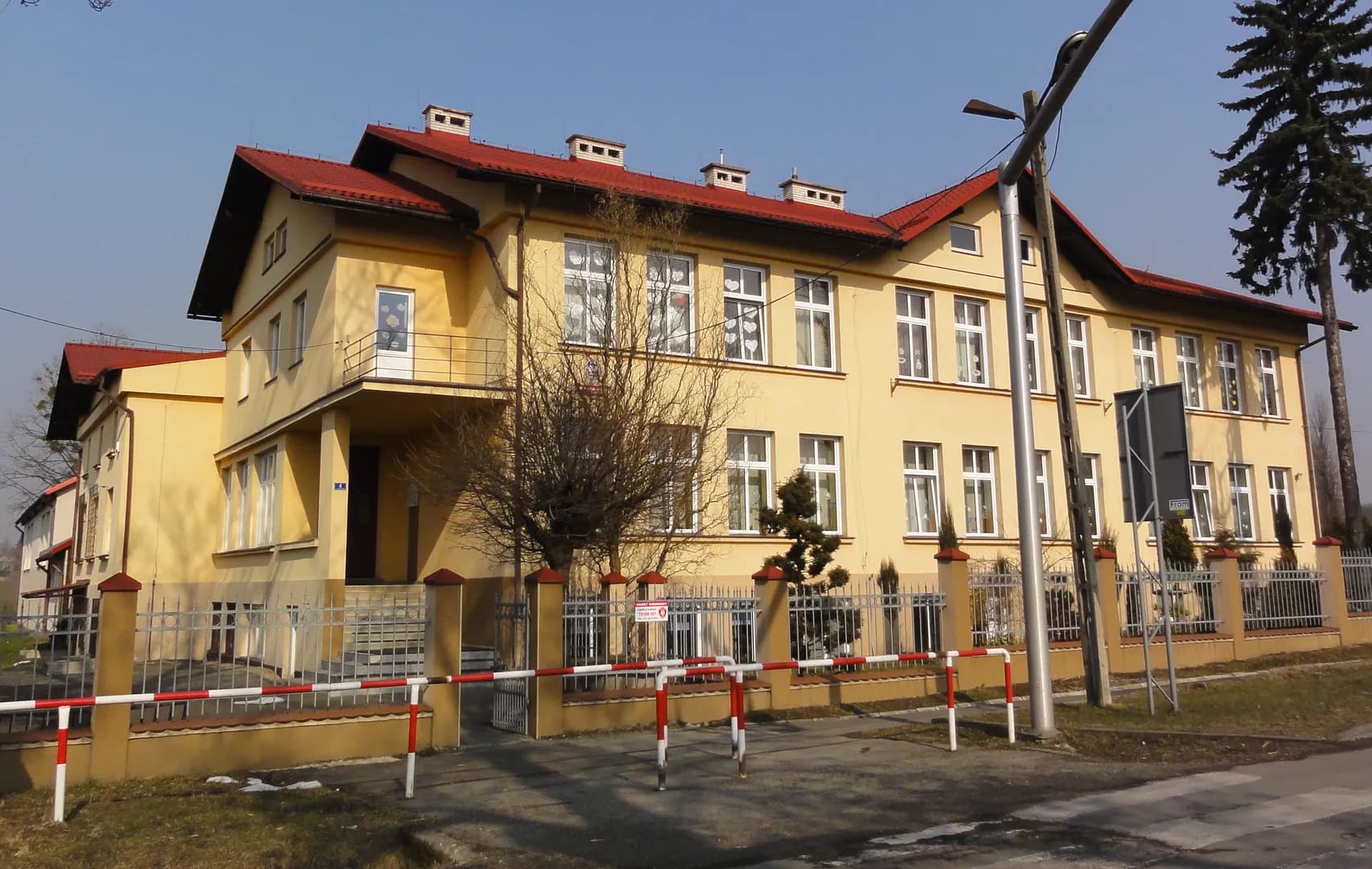 Budynek Szkoły Podstawowej w Dzięgielowie z żółtą elewacją i czerwonym dachem