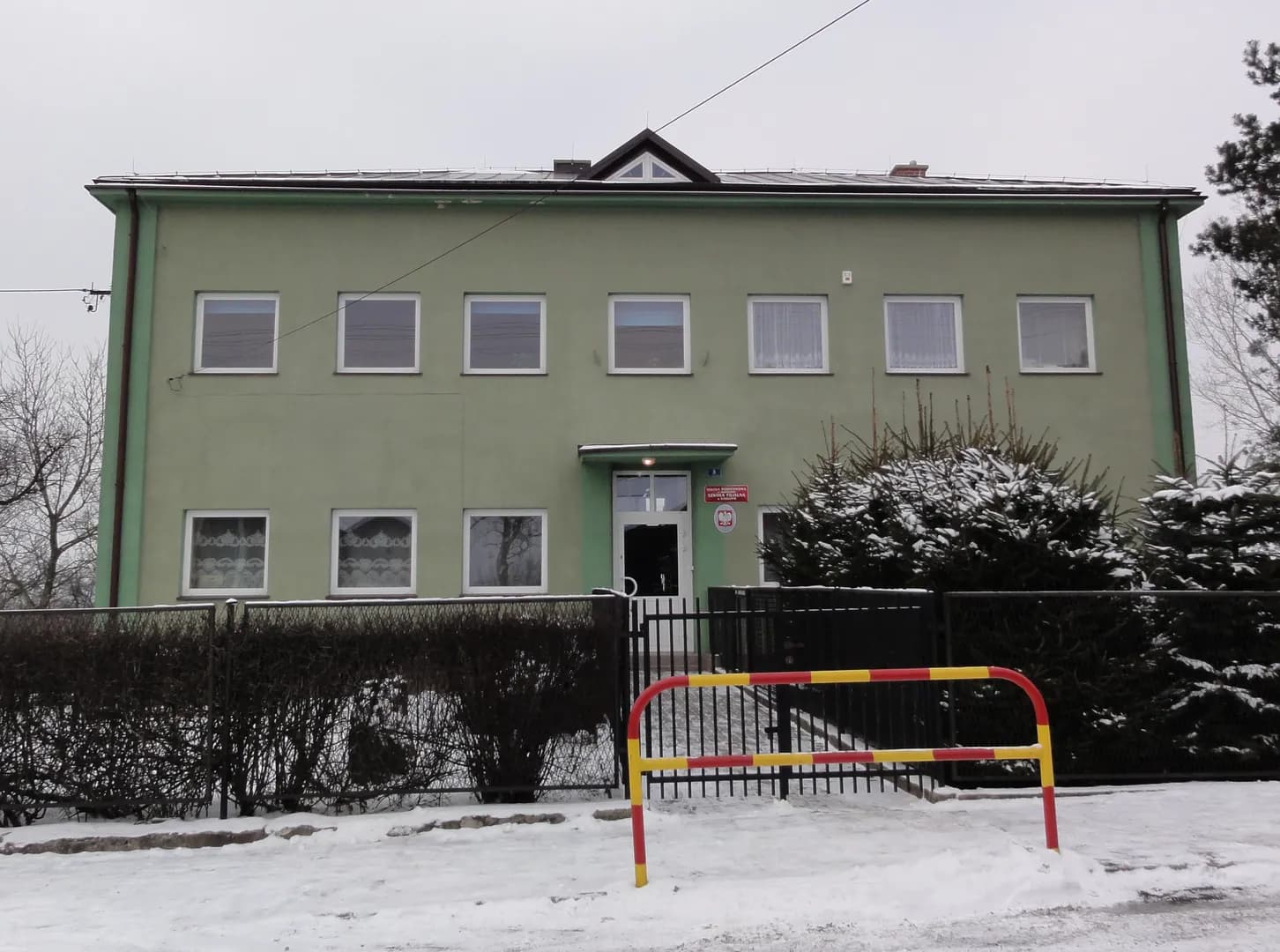 Elewacja frontowa budynku szkoły w Kisielowie w zimowej scenerii
