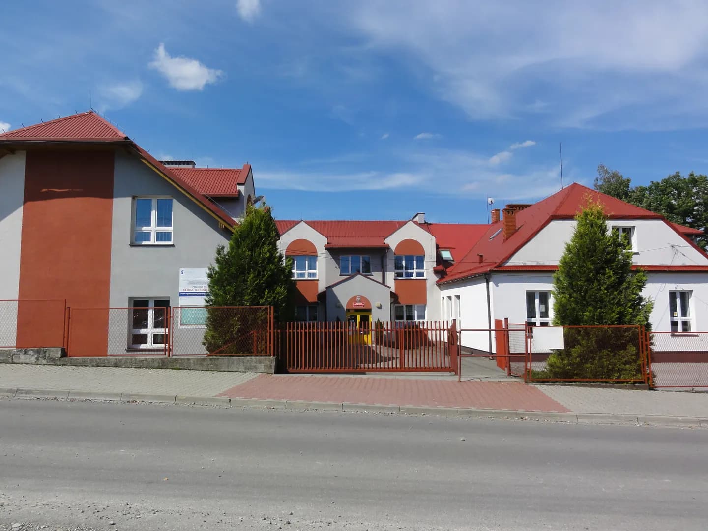 Budynek Szkoły Podstawowej w Twardorzeczce z czerwonym dachem