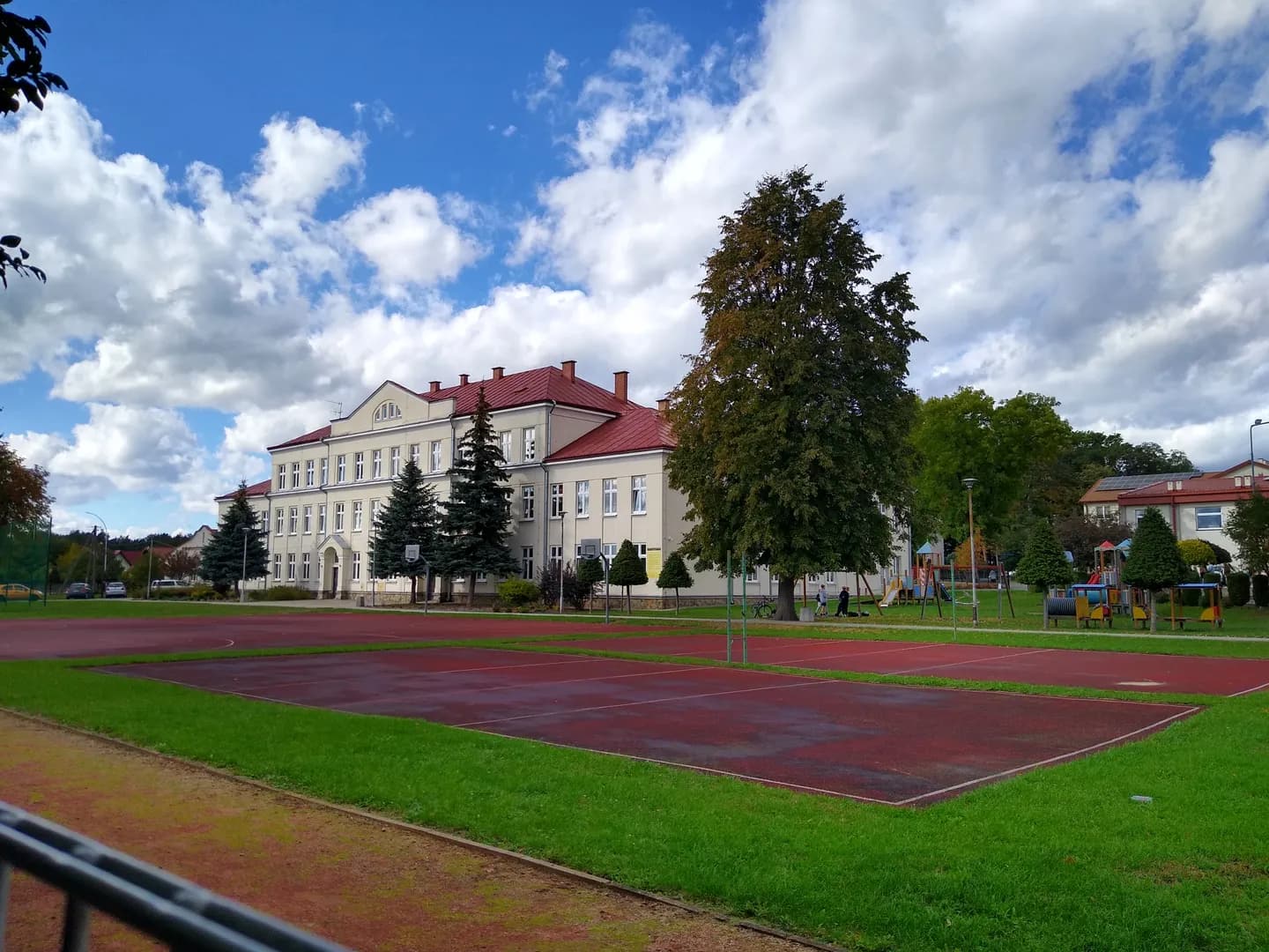 Budynek szkoły podstawowej w Głogowie Małopolskim z boiskiem szkolnym na pierwszym planie