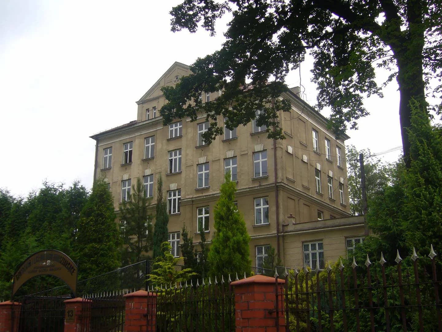Wielopiętrowy budynek Zespołu Szkół Zgromadzenia Córek Bożej Miłości w Bielsku-Białej za ogrodzeniem
