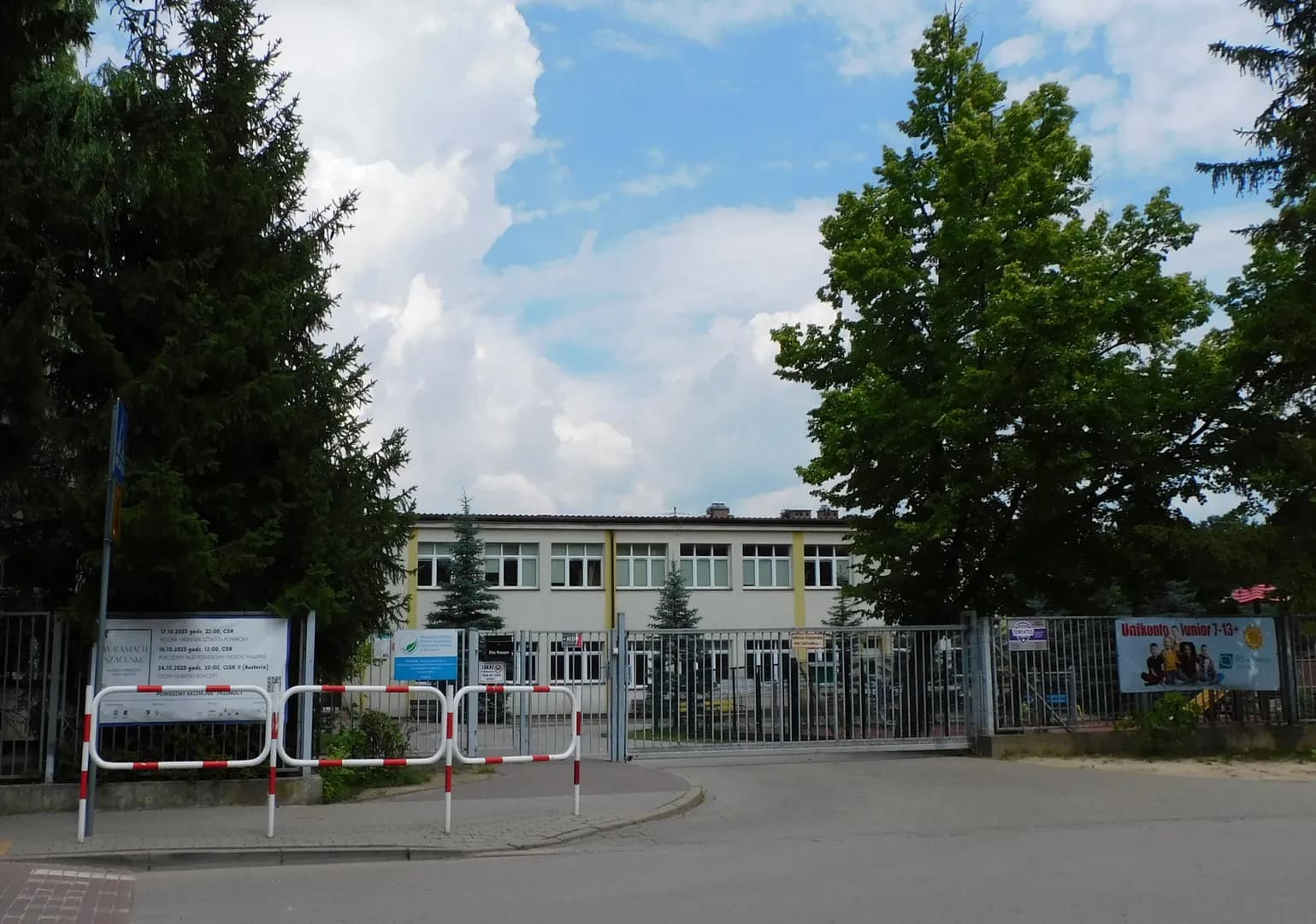 Widok na budynek Szkoły Podstawowej w Sękocinie zza ogrodzenia