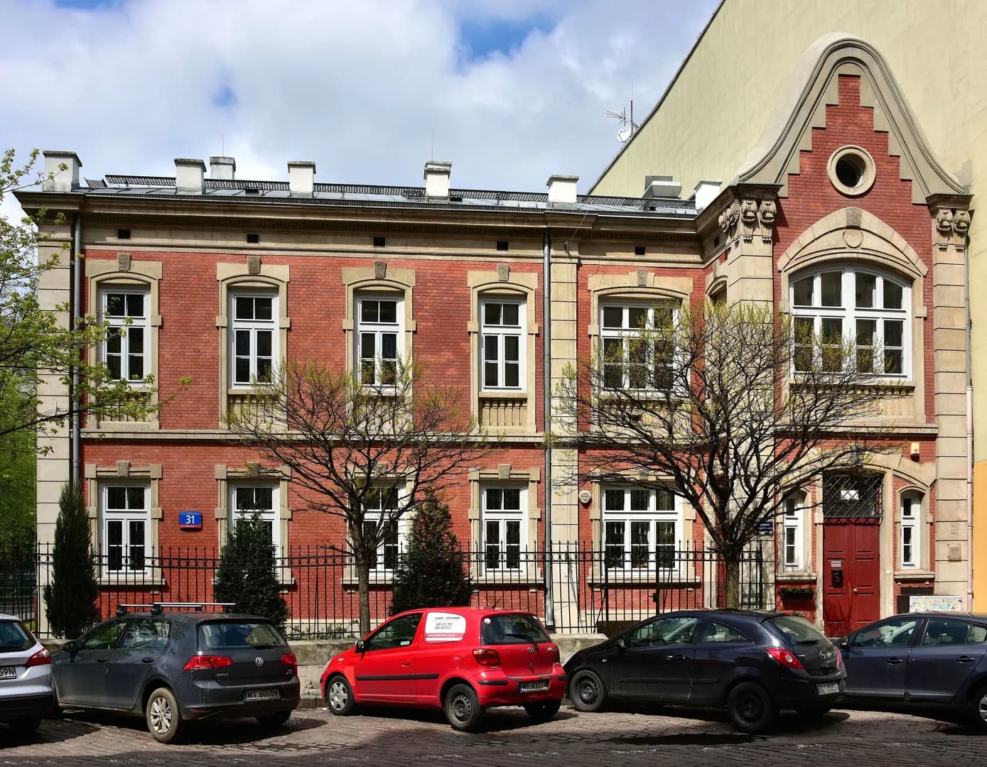Zabytkowy ceglany budynek liceum przy ulicy Kłopotowskiego 31 w Warszawie