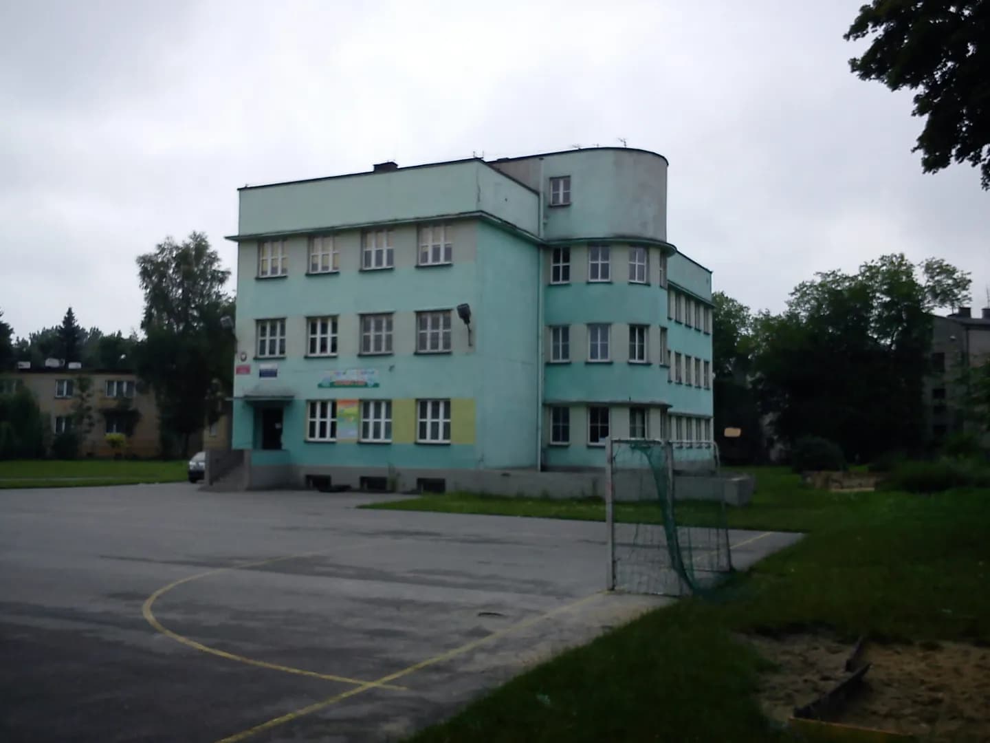 Budynek Szkoły Podstawowej nr 11 w Sosnowcu z boiskiem szkolnym na pierwszym planie