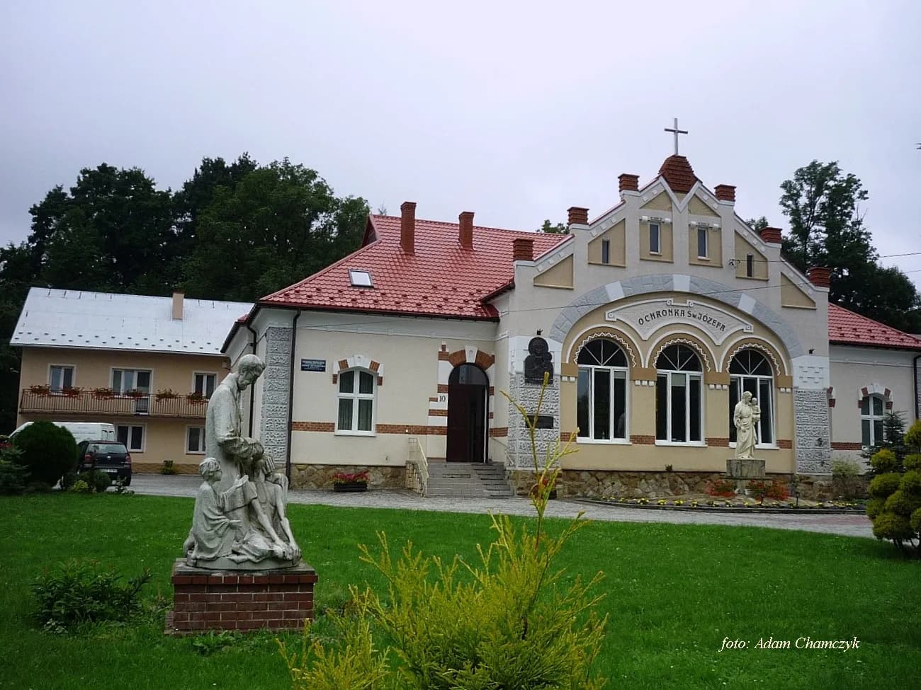 Elewacja frontowa budynku Przedszkola Św. Józefa w Rymanowie z ogrodem i figurami