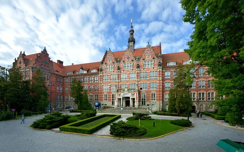 Gmach Główny Politechniki Gdańskiej z widocznym dziedzińcem i zielenią